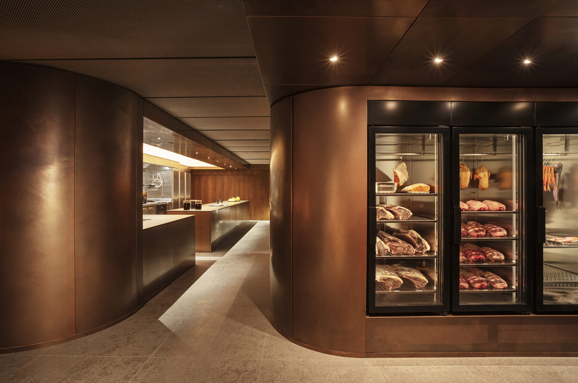 Ikoyi restaurant copper-clad kitchen passage with warm walnut joinery and bespoke refrigeration